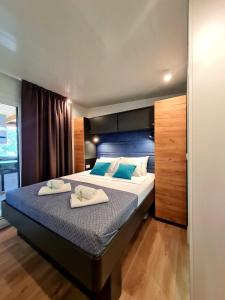 a bedroom with a large bed with two towels on it at Rosmarin&Olive Premium Mobile Homes in Selce