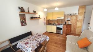a living room with a table and a kitchen at Appartamento Gressoney-Saint-Jean (Obre Biel) - I Larici in Gressoney-Saint-Jean