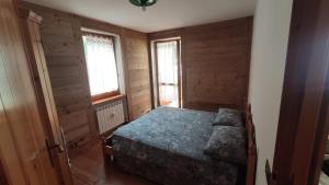 a bedroom with a bed in a room with wooden walls at Appartamento Gressoney-Saint-Jean (Obre Biel) - I Larici in Gressoney-Saint-Jean