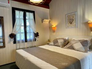 a bedroom with a large bed and a window at Pousada Caliandra Da Serra in Canela