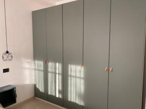 a living room with white cabinets and a tv at Appartamento L'Olivo in Latina