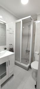 un bagno bianco con doccia e WC di TURISSTIKO Playa Carvajal a Fuengirola