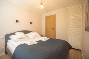 a bedroom with a bed with white pillows on it at Apartament Jelonek Zdrój in Polanica-Zdrój