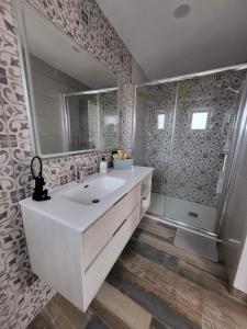 y baño con lavabo blanco y ducha. en Country Cottage Cabana, en Granadilla de Abona
