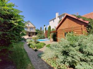 a garden in front of a house with a pool at Приватний котедж з Басейном біля моря Совіньон Одеса in Odesa