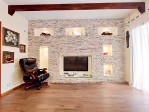 a room with a brick wall with a chair and a television at Приватний котедж з Басейном біля моря Совіньон Одеса in Odesa
