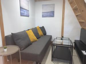 Sala de estar con sofá gris y mesa en Appartement - Proche CDG - Paris & Stade de France, en Aubervilliers