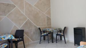 a room with three tables and chairs and a wall at B&B L'agrumeto in Nocera Inferiore