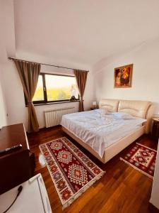 sypialnia z łóżkiem i dużym oknem w obiekcie Belvedere Resort Moieciu w mieście Moieciu de Jos