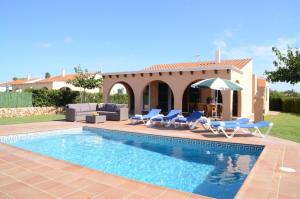 a villa with a swimming pool and a patio at Villas Las Golondrinas in Cala'n Bosch