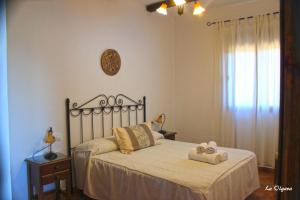 a bedroom with a bed with two towels on it at La Olgava in El Gastor