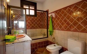 a bathroom with a toilet and a sink at La Olgava in El Gastor +16 photos