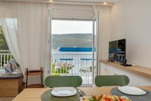 a dining room with a table with a plate of fruit on it at Tamaris beach apartment in Herceg-Novi