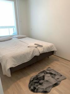 a bedroom with a bed and a rug on the floor at Modern city apartment with Sauna nearby the Airport in Vantaa