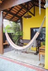 a hammock on a porch of a house at Pousada Quatro Estrelas in Penha