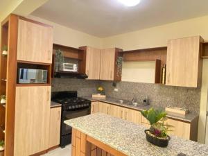 a kitchen with wooden cabinets and a granite counter top at Apartamento Pareche in Mata Chalupe