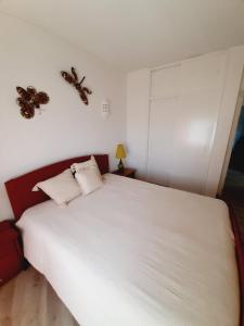 a bedroom with a white bed with two butterflies on the wall at Carol Beach House in Armação de Pêra