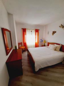 アルマカオ・デ・ペラにあるCarol Beach Houseのベッドルーム(大きな白いベッド1台、鏡付)