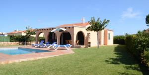 a villa with a swimming pool and a house at Villas Las Golondrinas in Cala'n Bosch
