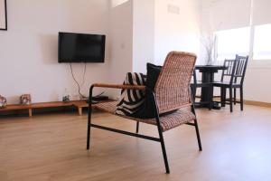 een woonkamer met een stoel en een tv bij A Nossa Casa da Costa in Costa da Caparica