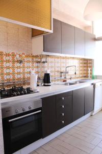 een keuken met een fornuis en een spoelbak bij A Nossa Casa da Costa in Costa da Caparica