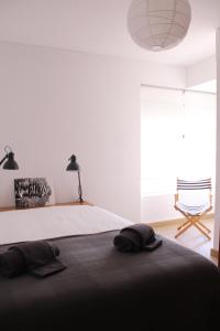 een slaapkamer met een bed en een groot raam bij A Nossa Casa da Costa in Costa da Caparica +17 foto's