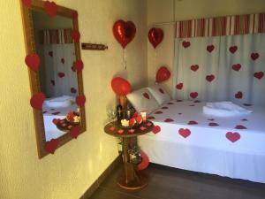 1 dormitorio con 1 cama con corazones y globos en Pousada Quatro Estrelas, en Penha