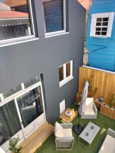 une petite maison avec une table et des chaises et une maison bleue dans l'établissement The Violet House, à Costa Nova