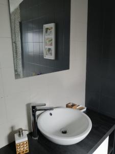 La salle de bains est pourvue d'un lavabo blanc et d'un miroir. dans l'établissement The Violet House, à Costa Nova