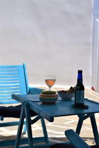 a picnic table with a wine glass and a bottle at Το κάτω σπίτι της Μαριάνθης in Márpissa