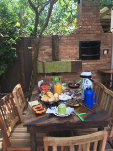 una mesa de madera con comida y bebidas. en Pousada Quatro Estrelas, en Penha