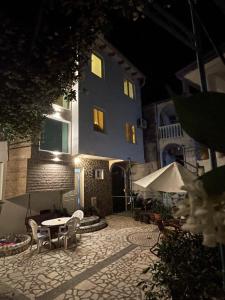 a building with a table and chairs in a courtyard at night at Casa Alea in Ulcinj