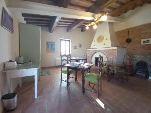un soggiorno con tavolo, sedie e camino di Agriturismo Podere Padolecchie - Azienda Agricola Passerini a Torrita di Siena