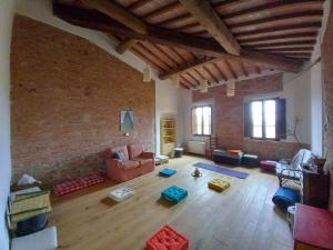 een woonkamer met een bank en een bakstenen muur bij Agriturismo Podere Padolecchie - Azienda Agricola Passerini in Torrita di Siena