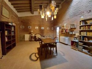 ein Esszimmer mit einem Tisch und Stühlen in einer Bibliothek in der Unterkunft Agriturismo Podere Padolecchie - Azienda Agricola Passerini in Torrita di Siena