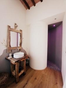 W łazience znajduje się umywalka i lustro. w obiekcie Agriturismo Podere Padolecchie - Azienda Agricola Passerini w mieście Torrita di Siena