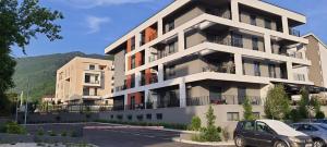 an apartment building with cars parked in a parking lot at Luxury apartment Stefanija in Tivat