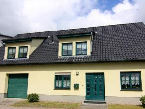 a yellow house with a black roof at Apartment at the Castle Square in Wolgast