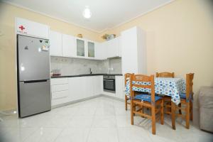 a kitchen with a refrigerator and a table and chairs at DANTE APARTAMENT in Vlorë
