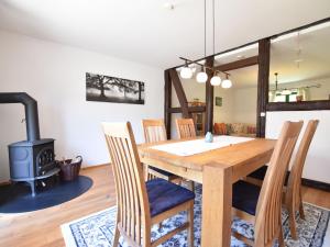 a dining room with a wooden table and a wood stove at Spacious Holiday Home in Landstorf Zierow with beach nearby in Zierow