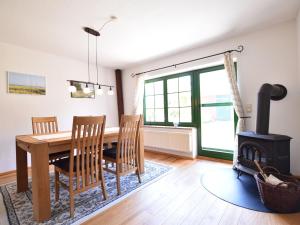 a dining room with a table and a wood stove at Spacious Holiday Home in Landstorf Zierow with beach nearby in Zierow