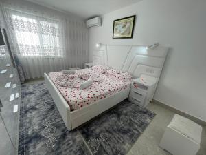 Un dormitorio con una cama blanca con almohadas rojas. en ROMANCE Apartments, en Tirana