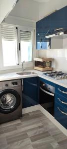 a kitchen with blue cabinets and a washing machine at The Oxygen 7 in Tetouan