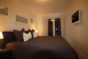 a bedroom with a bed with pillows and a window at Villa Meeresrauschen, Ostseeperle in Pelzerhaken +13 photos
