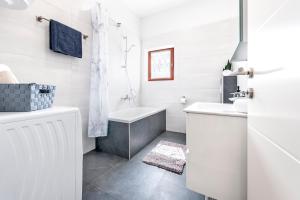 un bagno bianco con vasca e lavandino di Apartments E&M a Pola (Pula) Altre 37 foto