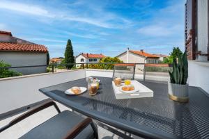 une table avec deux assiettes de nourriture sur un balcon dans l'établissement Apartments E&M, à Pula