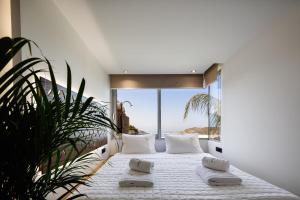 1 dormitorio con 1 cama y vistas al océano en DOMUS AESTAS Luxury Residences en Plakiás