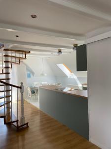 een keuken en een woonkamer met een trap in een huis bij Windhouse in Jastarnia