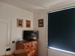 ein Wohnzimmer mit einem großen Fenster und einem TV in der Unterkunft Hikers & Bikers Refuge in Ipswich