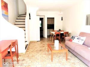 uma sala de estar com um sofá e uma mesa em Appartement 16 en duplex, deux chambres - LES SUITES DE ROBINSON - Résidence avec piscine en bord de Siagne, à Mandelieu-La-Napoule em Mandelieu-la-Napoule